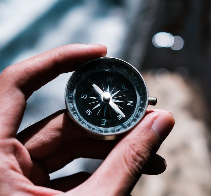 a person holding black and silver compass