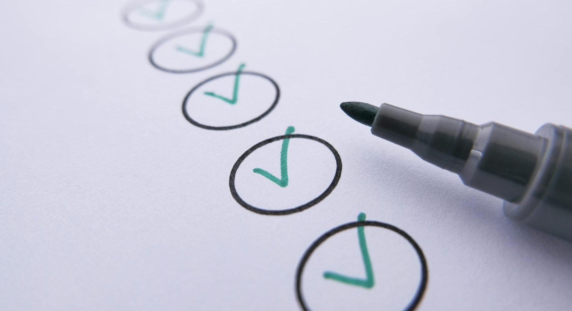 a marker near checked circles on white paper