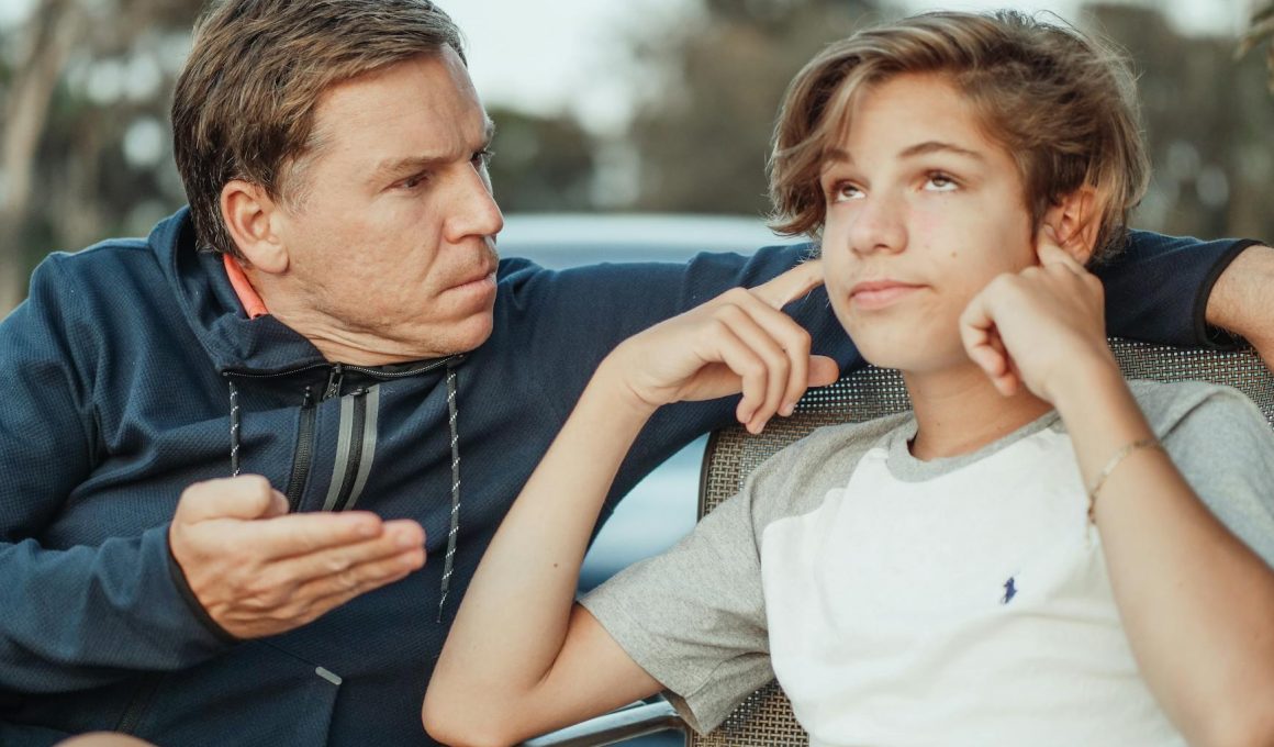 man scolding his son
