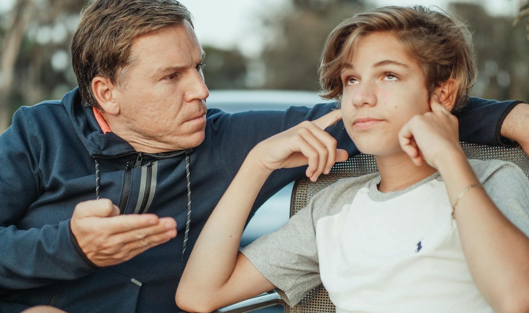 man scolding his son