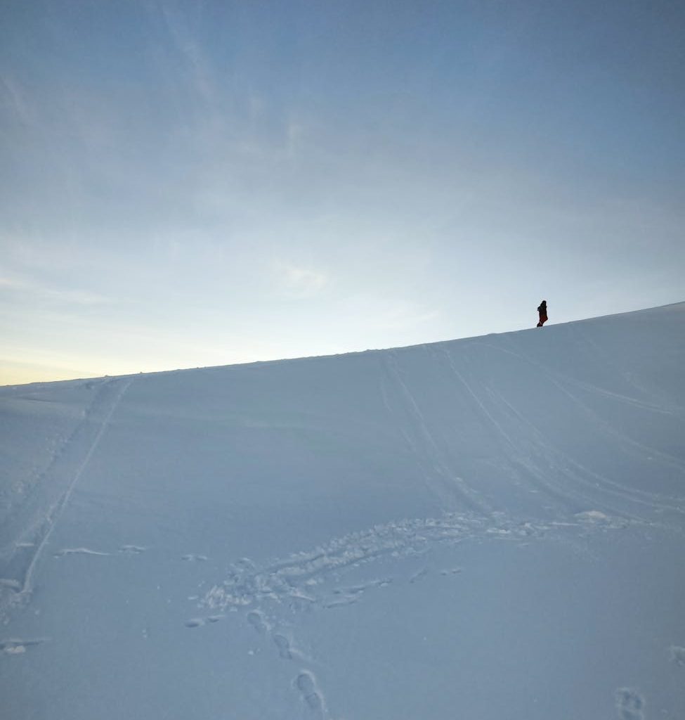 solitary figure on a snowy slope at dusk