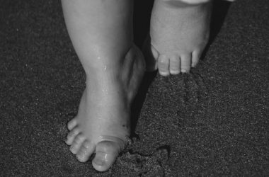 toddler s barefoot steps in sand at night