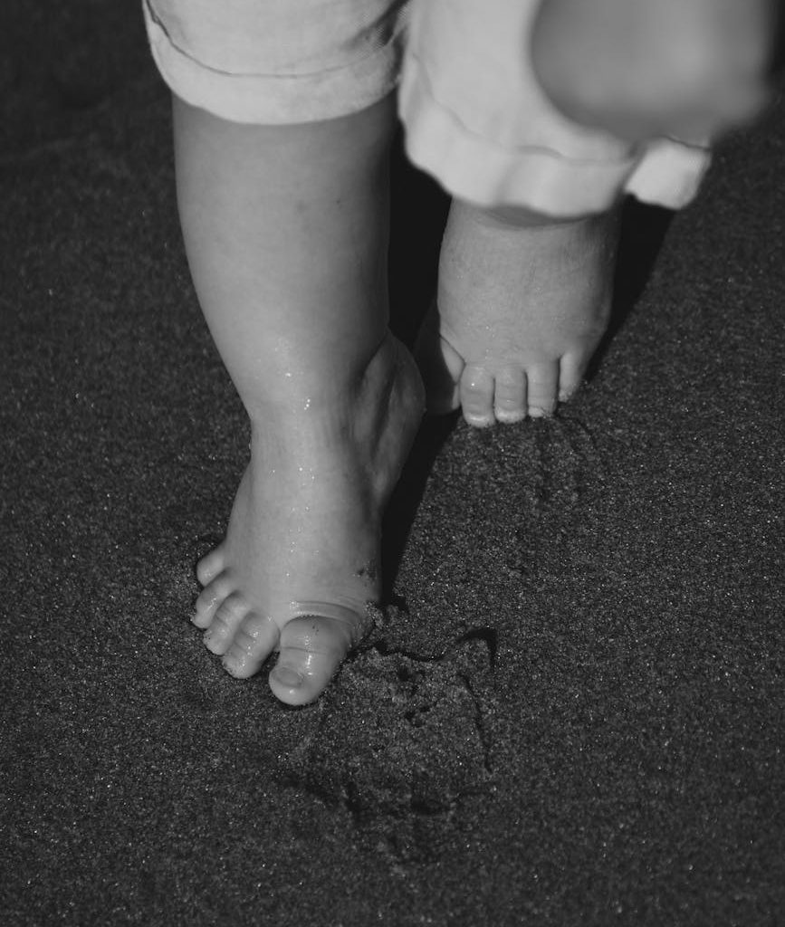 toddler s barefoot steps in sand at night
